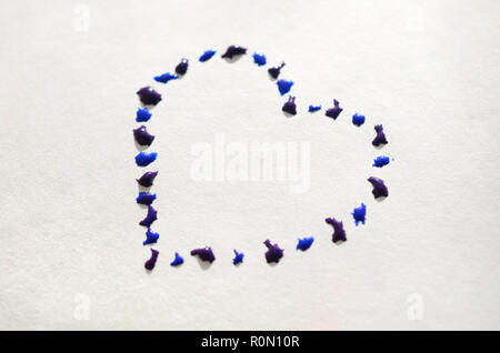 Image of a heart made from wet drops of watercolor paint on a paper sheet . Stock Photo