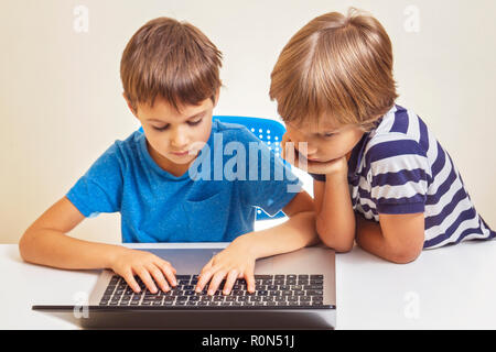 Two kids with laptop computer Stock Photo - Alamy