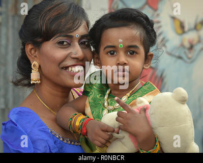 Dressed-up, young Malaysian Indian woman and her little toddler girl during Thaipusam. Stock Photo