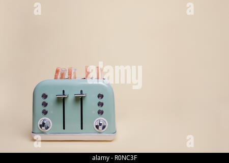 Retro green four slice double toaster filled with toast on a vintage tan background with copy space and room for text Stock Photo