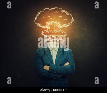 Surreal image nervous man with crossed hands head explosion over blackboard background as nuclear mushroom sketch. Mental state problems, business fai Stock Photo