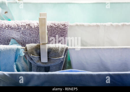 Laundry on a clothesline drying with a white plastic peg Stock Photo