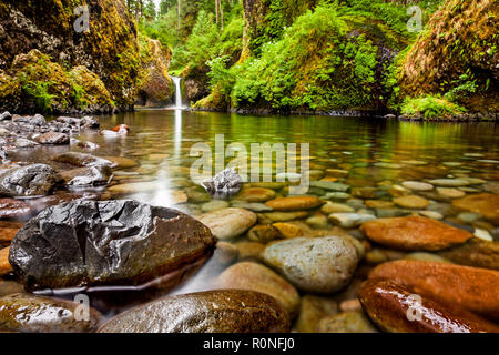 Punch Bowl Falls along the Eagle Creek Trail in Oregon with focus on the rocks in the foreground Stock Photo