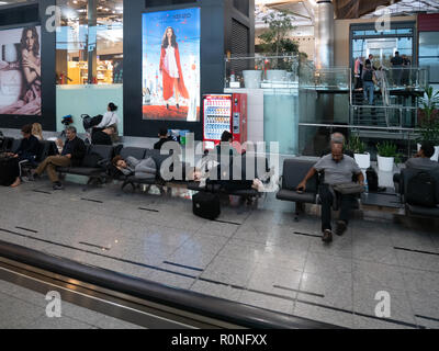 ISTANBUL, TURKEY - SEPTEMBER 27, 2018: People sleeping at chairs waiting for departure at Istanbul Airport Stock Photo