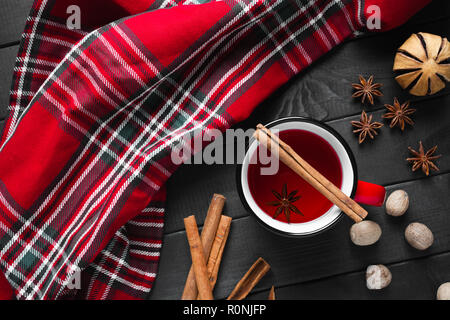 Christmas mulled wine with spices in red mug on wooden background. Stock Photo