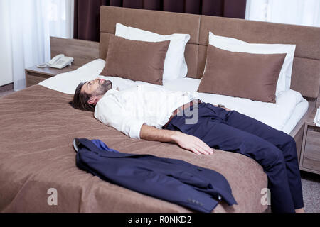 Handsome smart man being exhausted from work Stock Photo