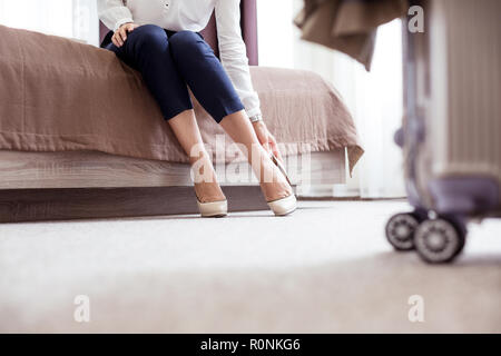 Nice young woman taking off her shoes Stock Photo