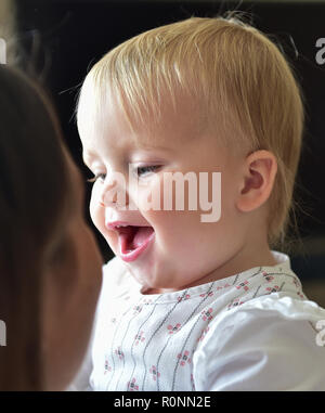 Young baby toddler girl aged two years old looking cute laughing Photograph taken by Simon Dack Stock Photo