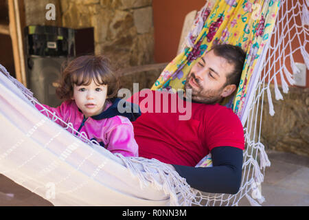 Father and daughter lying in a hammock Stock Photo