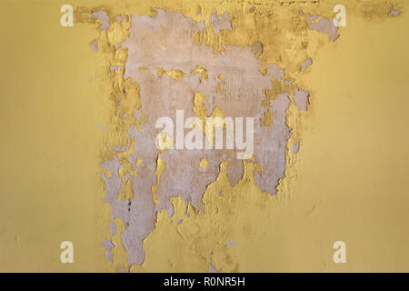 Old cracked yellow plaster on the wall. Grunge texture background. Stock Photo