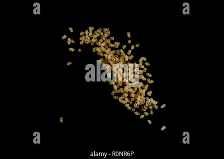 Flying pasta isolated on black background. Abstract macaroni falling. Stock Photo