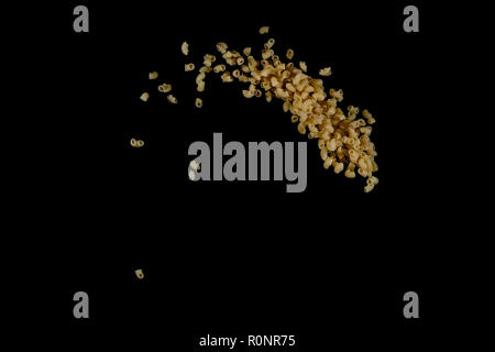 Flying pasta isolated on black background. Abstract macaroni falling. Stock Photo