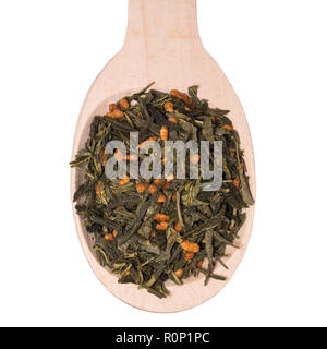 Japanese green tea Genmaicha in a wooden spoon isolated on white background. Tea leaves with roasted brown rice Stock Photo