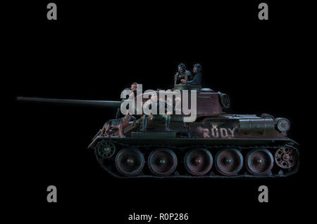 Model of the Russian battle tank T-34 fighting vehicle, with three soldiers nearby. Black background Stock Photo