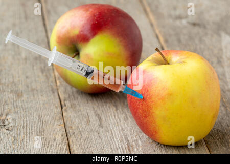 Syringe in apple. Concept for genetically modified food and cosmetic medicine Stock Photo