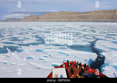 Scientists at the prow of the CCGS Amundsen as she breaks through the ice in Lancaster Sound, Arctic Canada