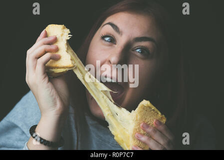 baked toast with stretched cheese in the hands of a woman Stock Photo