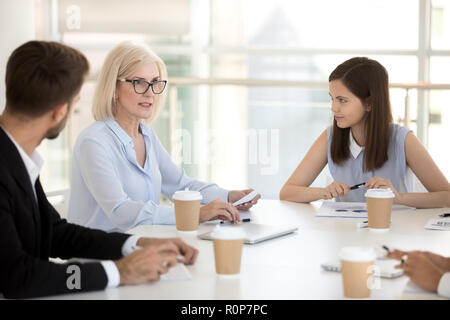 Young employees listen to female boss talking during briefing Stock Photo