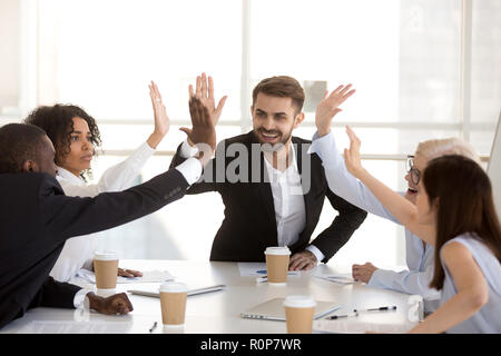 Excited diverse employees give high five celebrating success Stock Photo