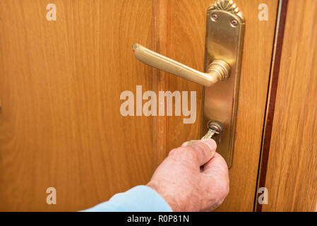 Senior man Locking up door with key in hand Stock Photo