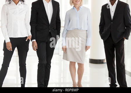 Legs of diverse work managers posing in office hallway Stock Photo