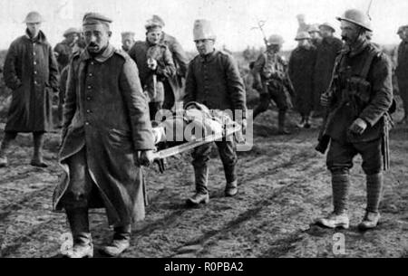 A British soldier supervising captured German prisoners of War to carry the  injured from the battlefield Stock Photo