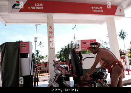 Mentawai Islands, West Sumatra, Indonesia. 3rd Nov, 2018. MENTAWAI ISLANDS, INDONESIA - NOVEMBER 07 : A Sikerei, a Mentawai shaman, is filling gasoline at the Pertamina fuel oil station on Siberut Island on November 03, 2018 in Mentawai islands, West Sumatra Province, Indonesia. The Mentawai Islands have a unique culture because they still preserve shamans called Sikerei for treatment for their people. Sikerei is dressed in minimal clothing with various leaves and flowers on the Mentawai Islands. Credit: Sijori Images/ZUMA Wire/Alamy Live News Stock Photo