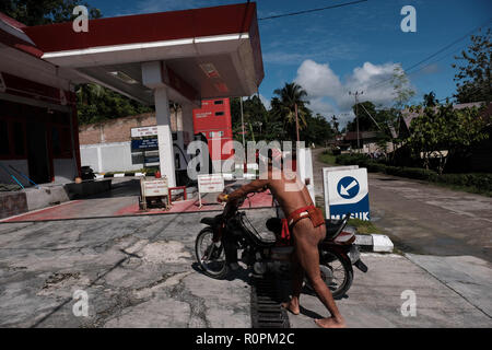 Mentawai Islands, West Sumatra, Indonesia. 3rd Nov, 2018. MENTAWAI ISLANDS, INDONESIA - NOVEMBER 07 : A Sikerei, a Mentawai shaman, is filling gasoline at the Pertamina fuel oil station on Siberut Island on November 03, 2018 in Mentawai islands, West Sumatra Province, Indonesia. The Mentawai Islands have a unique culture because they still preserve shamans called Sikerei for treatment for their people. Sikerei is dressed in minimal clothing with various leaves and flowers on the Mentawai Islands. Credit: Sijori Images/ZUMA Wire/Alamy Live News Stock Photo