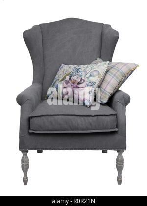 Traditional grey arm chair with  floral and checkered cushions, isolated on a white background. Stock Photo