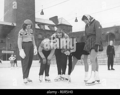 Female ice skaters in the 1940s. Second right ice skater champion Britta råhlén with friends on Stockholm stadium, where the look at something in the ice. Sweden 1940s Stock Photo