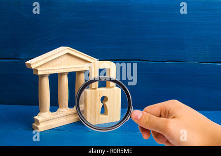 Magnifying glass is looking at the ancient building and a lock. The concept of preserving monuments of history and culture. Protection of museums. Pro Stock Photo