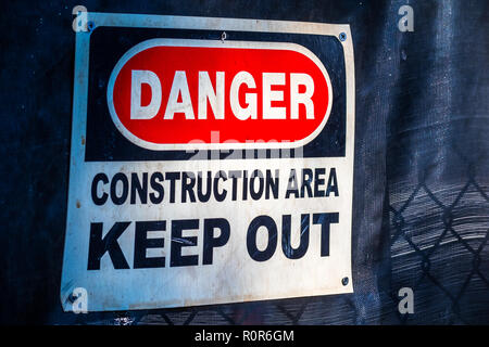 "Danger Construction Area Keep Out" sign posted on a fence at a construction site Stock Photo