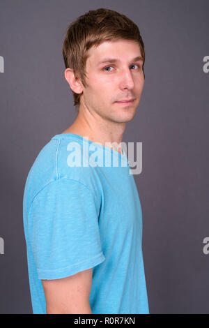 Portrait of young handsome man against gray background Stock Photo