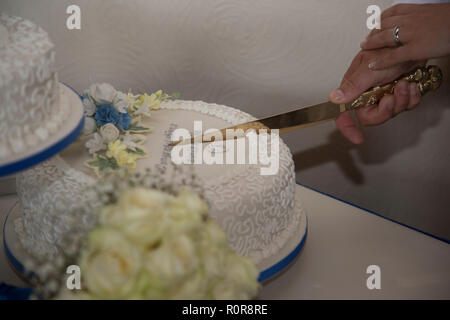 close up of bride and groom cutting their wedding cake on their wedding day showing just hands and knife and the cake Stock Photo