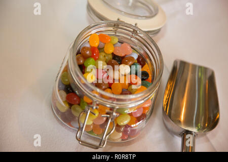 jelly beans in a kilner jar on a table at a wedding waiting for the guests to dig in and eat them Stock Photo