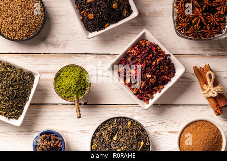 From above various spices in small plates on white wooden background Stock Photo