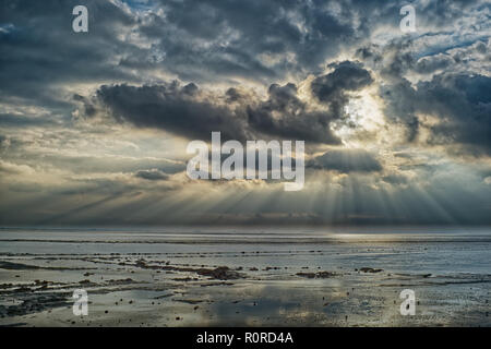 Sunlight streaming through the clouds over the Dollard at low tide, East Frisia, Lower Saxony, Germany Stock Photo