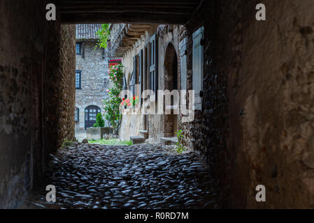 View of a cobbled courtyard framed by a square arch in the French monastery of Sainte-Croix-en-Jarez. Stock Photo