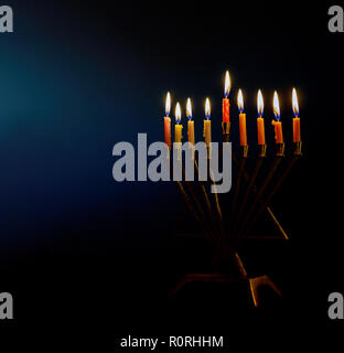 Golden menorah lighted candles on menorah for the jewish holiday Hanukkah. Stock Photo