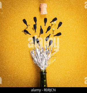 From above opened  bottle with silver decoration simulating champagne and cork on golden background Stock Photo