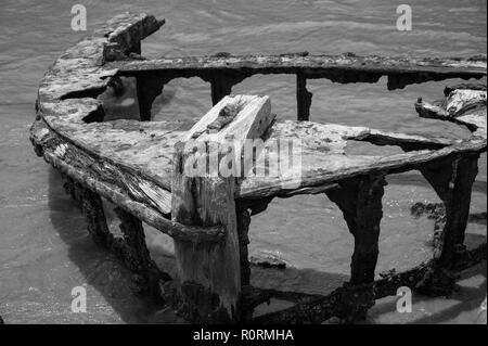 Old shipwreck, Galle Fort, Sri Lanka, Black and white image, rusted remains of fishing vessel on shoreline. Stock Photo