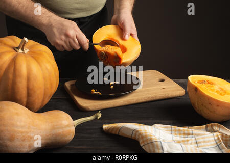 The cook separates the grain from the pumpkin cut in half. Stock Photo