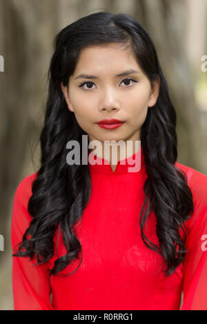 Portrait of a pretty Vietnamese woman in red Ao Dai Stock Photo