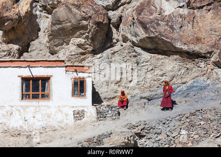 Two Buddhist monks near the building which is part of Phugtal Gompa (also known as Phuktal Gompa), Zanskar, Jammu and Kashmir, India Stock Photo