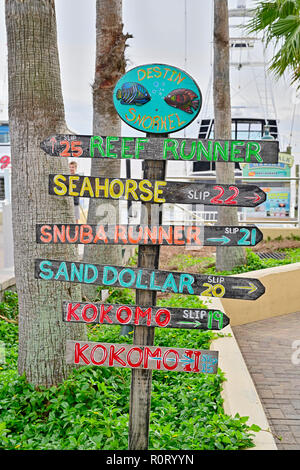 Colorful directional sign or signs pointing to charter fishing boat slips