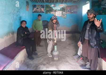 Men smoking hashish with a bong near the tomb of a Sufi saint, Ancient Balkh, North Afghanistan Stock Photo