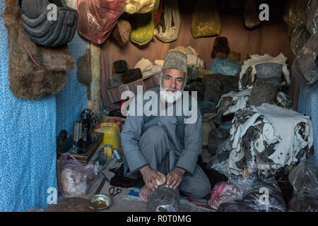 Man Manufacturing Fur Hats In Colourful Stall At The Mazar-e Sharif Central Bazaar, Maraz-e Sharif, Balkh Province, Afghanistan Stock Photo