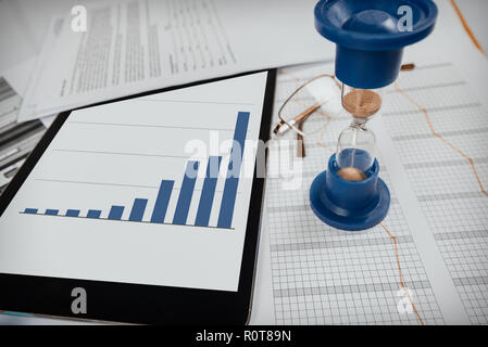 Hourglass. Businessman working in the office in the background. Concept time is money. Stock Photo