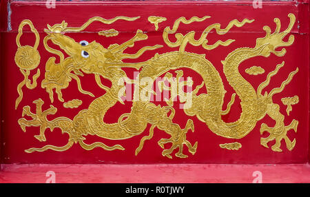 Ornate Chinise dragon motif in gold paint on red background Beijing, China Stock Photo