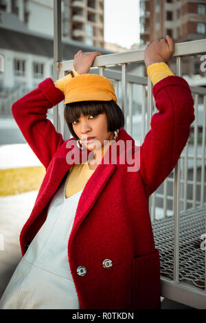 Fashionable colorful lady posing in woolen red coat Stock Photo